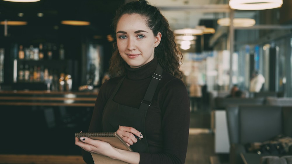 Smiling waitress holding a tablet in a restaurant